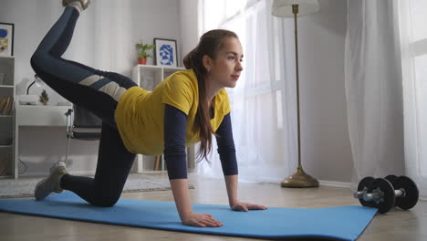 aerobic-training-at-home-young-woman-is-tensing-muscles-of-legs-doing-physical-exercises-on-floor-in-living-room-sport-activity-and-healthy-lifestyle